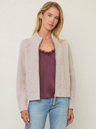 Person wearing the Tahoe Zip Up, a beige tneck cashmere zip up by Margaret O'Leary paired with blue jeans.