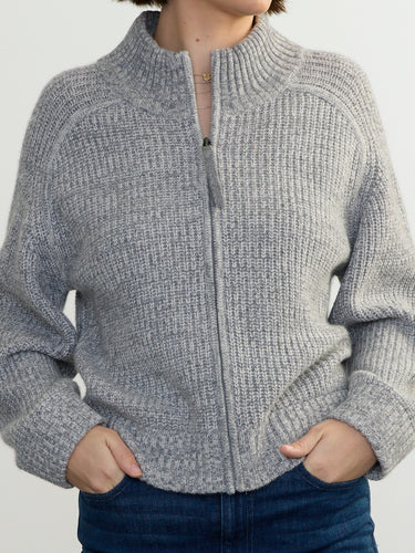 Person wearing the Tahoe Zip Up, a grey tneck cashmere zip up by Margaret O'Leary paired with blue jeans.