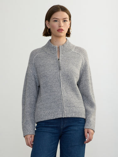 Person wearing the Tahoe Zip Up, a grey tneck cashmere zip up by Margaret O'Leary paired with blue jeans.