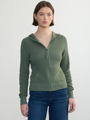 Person wearing the Thermal Hoodie a green waffle knit zip up hoodie by Margaret O'Leary paired with blue jeans.