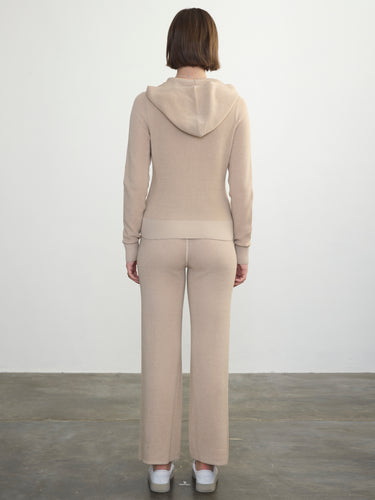 Person wearing the Thermal Hoodie a beige waffle knit zip up hoodie by Margaret O'Leary paired with matching lounge pants.