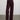Person wearing a floral blouse and The Trish Wide Leg Pant, adark burgundy high-waisted pants by Margaret O'Leary on a plain background