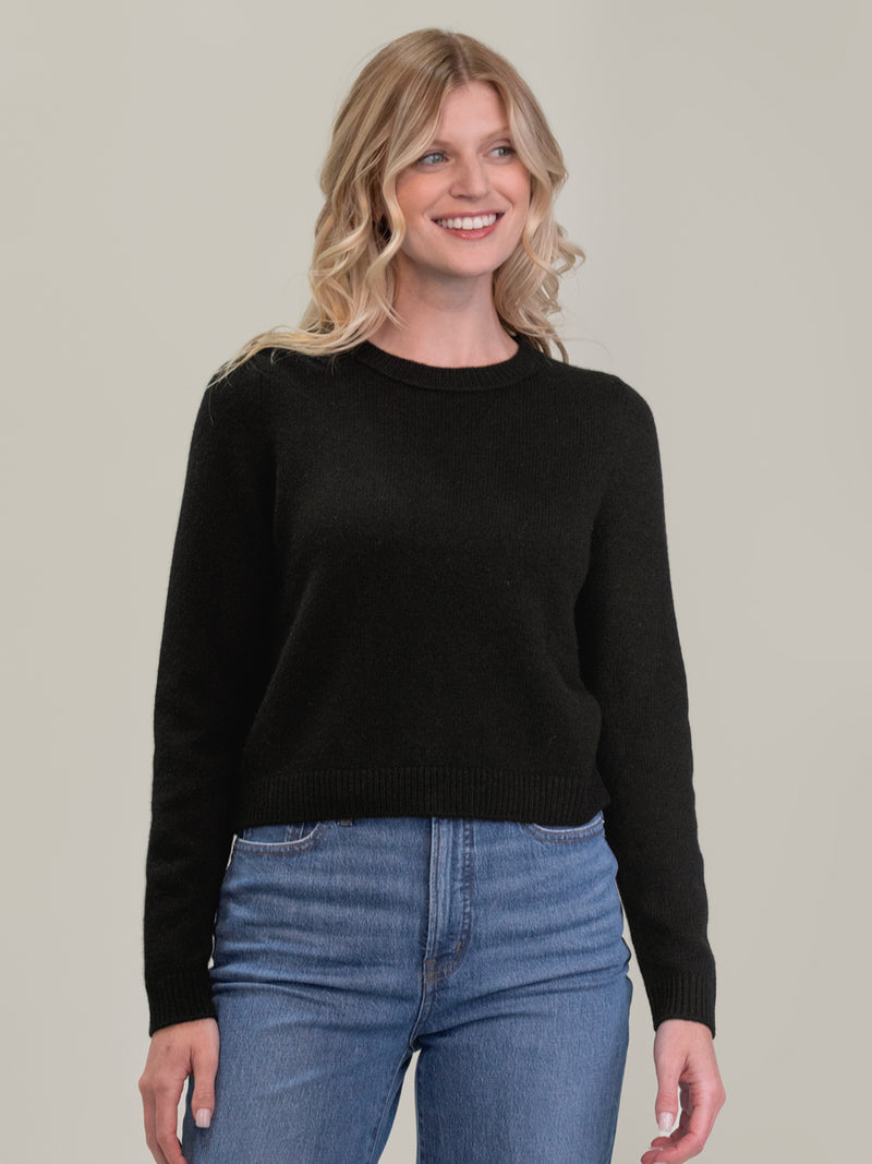 Woman wearing the cashmere pullover in black by Margaret O'Leary.