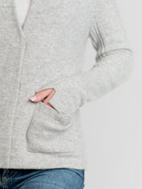 Woman wearing a fitted grey cashmere jacket.