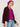 Woman wearing The Inverness Jacket, a purple cardigan by Margaret O'Leary, a pink shirt, and blue jeans on a white background