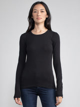 Portrait view of a woman wearing a black fitted long sleeve tee.