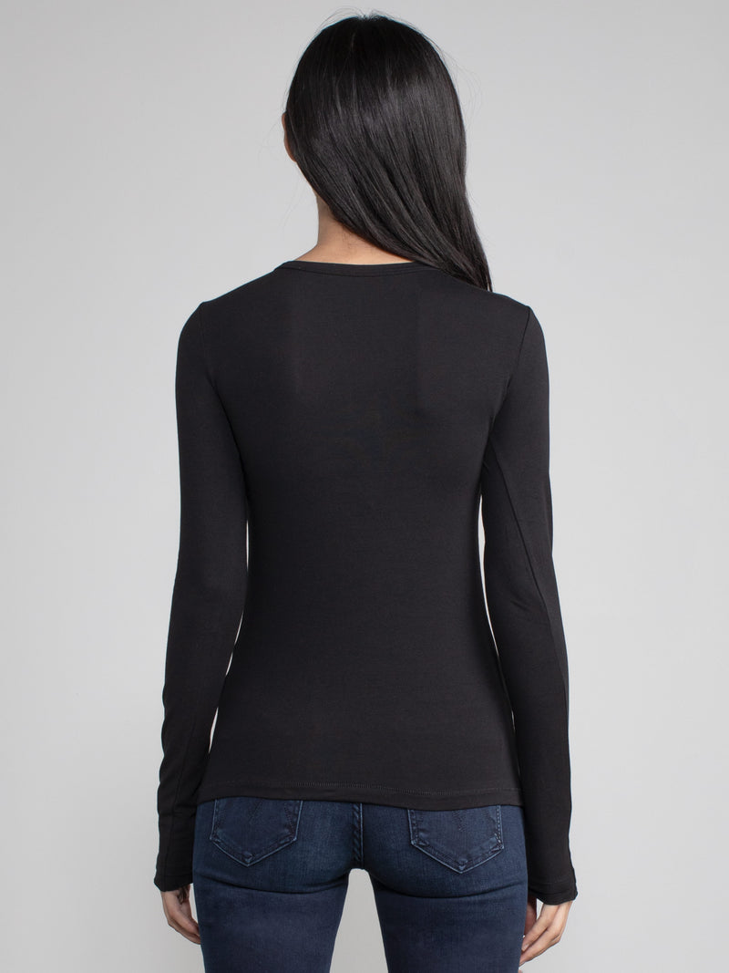 Black view of a woman wearing a black fitted long sleeve tee.