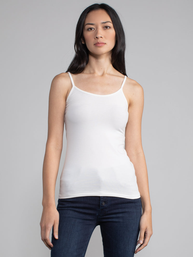 Portrait view of a woman wearing a fitted white camisole tank.