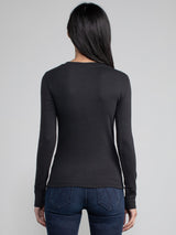 Back view of a woman wearing a black fitted long sleeve tee.