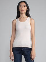 Portrait view of a woman wearing a fitted ribbed solid oat tank.