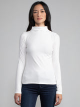 Portrait view of a woman wearing a white fitted long sleeve turtleneck tee.