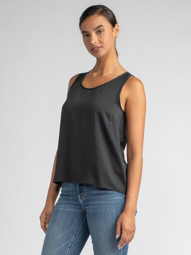 Model wearing a black silk tank and a pair of jeans.