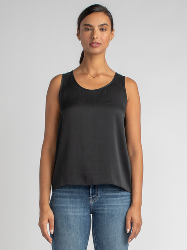 Model wearing a black tank and a pair of jeans.