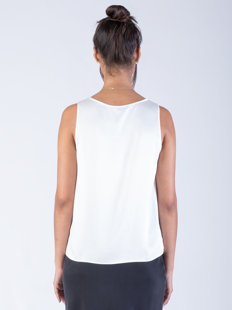 Back view of the model wearing a white silk tank and a black silk skirt.