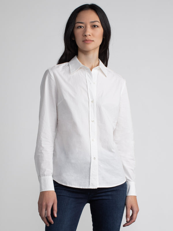 Model wearing a white shirt and a pair of jeans.