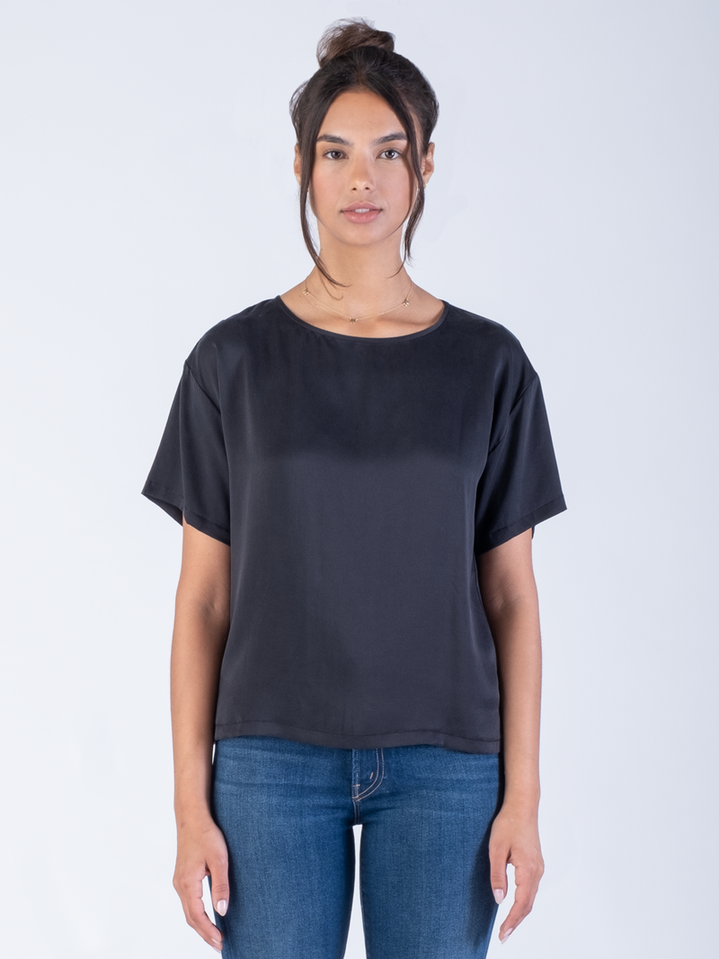 Model wearing a black silk tee and a pair of jeans.