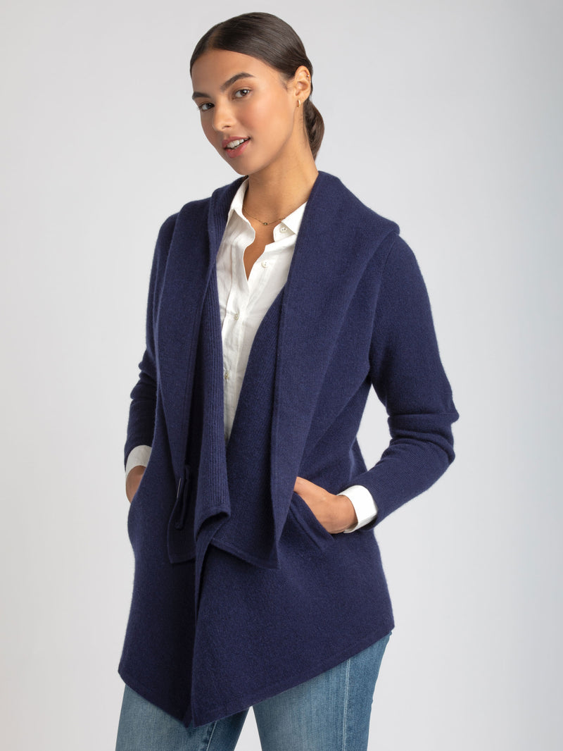 Model wearing a white shirt underneath a navy cashmere coat and a pair of jeans.