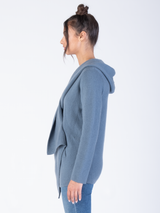 Side view: Model wears a white crew ribbed tee and a cashmere blue grey cardigan and a pair of jeans.