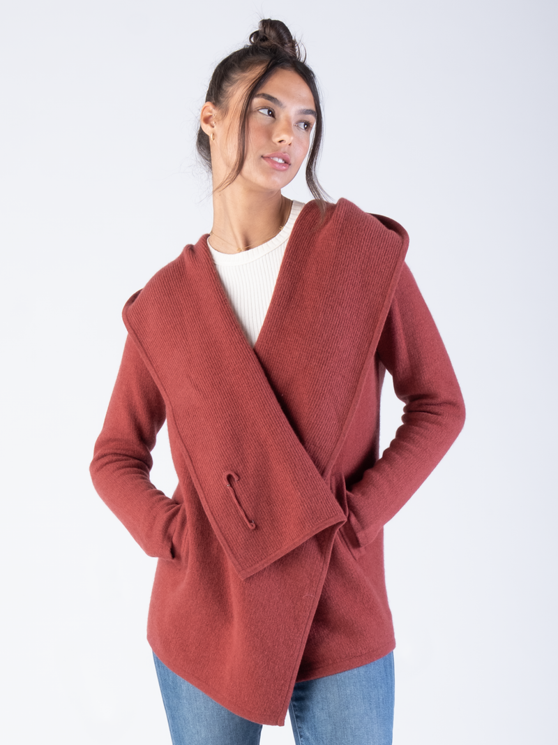 Woman wearing a red cashmere draped cardigan.