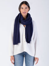 Model wearing the cashmere wrap in navy, tied loosely around her neck.