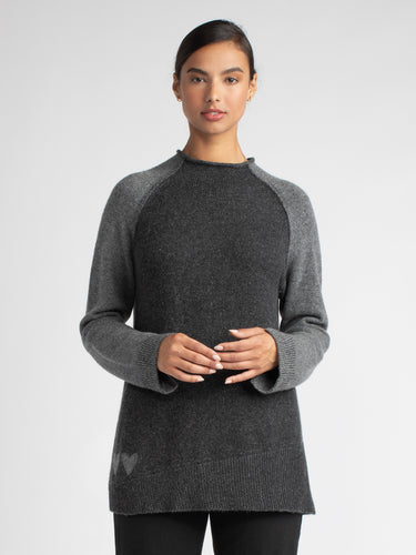 Model wearing a grey pullover with contrast-color raglan sleeves.