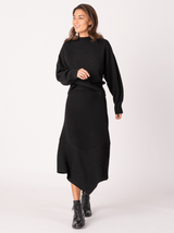 Front view of a model wearing a black pullover and the black knit skirt.