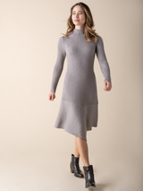 Model wearing a cement color knit dress and a pair of black boots.