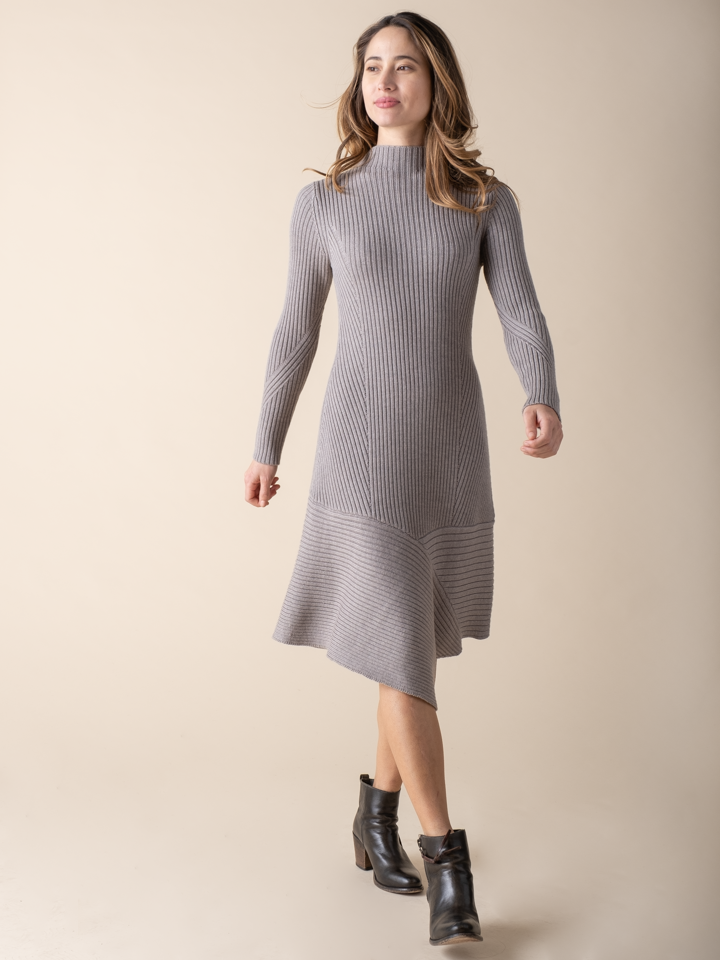 Model wearing a cement color knit dress and a pair of black boots.