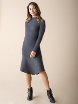 Model wearing a dark grey knit dress and a pair of black boots.