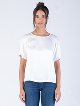Model wearing a white silk tee and a pair of jeans.