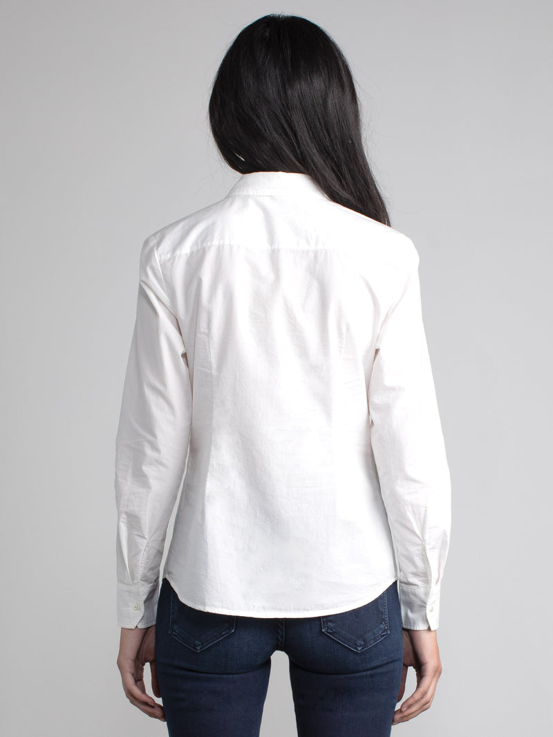 Back view of the model wearing a white shirt and a pair of jeans.