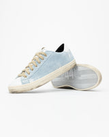 A pair of distressed denim lowtop sneakers, set against a bright white background.