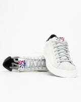 A pair of white and grey glitter sneakers, set against a bright white background.