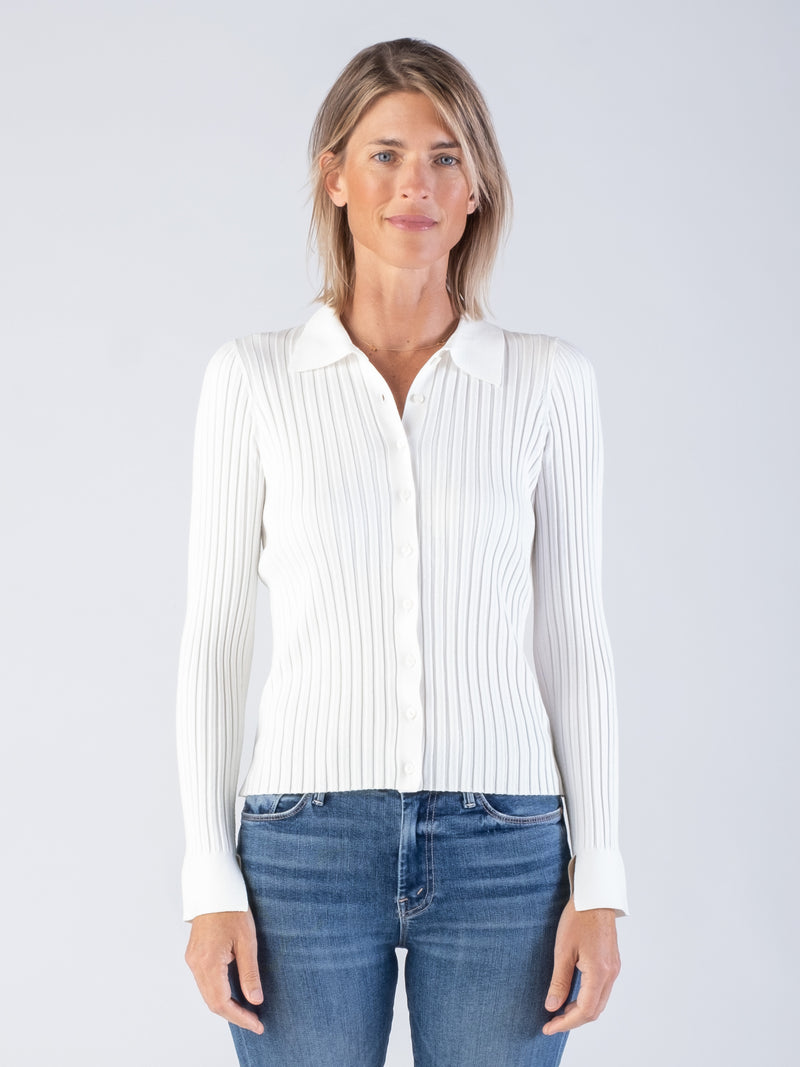 Model wearing a white ribbed fitted cardigan with a collar neckline and a pair of jeans.