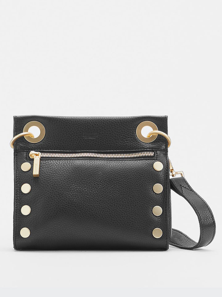 A black crossover bag with circular gold hardware at sides and by the strap and a gold zipper under the circular hardware by the strap. 