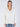 Model wearing a white linen vneck pullover with side slits and a pair of pants.