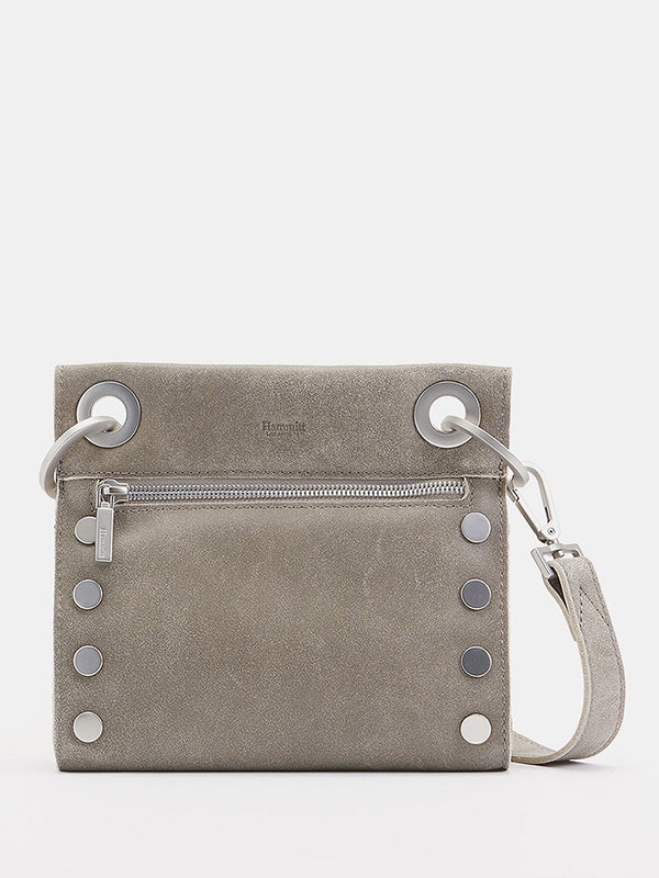 A grey crossover bag with circular silver hardware at sides and by the strap and a silver zipper under the circular hardware by the strap.