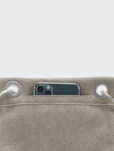 Closed up view of a grey bag with a phone in its phone pocket.