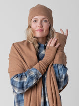 Model wearing a plain shirt, a pair of brown texting gloves, a brown beanie and a brown wrap around her shoulders.