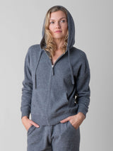 Model wearing a grey color cashmere hoodie and a pair of the grey joggers.