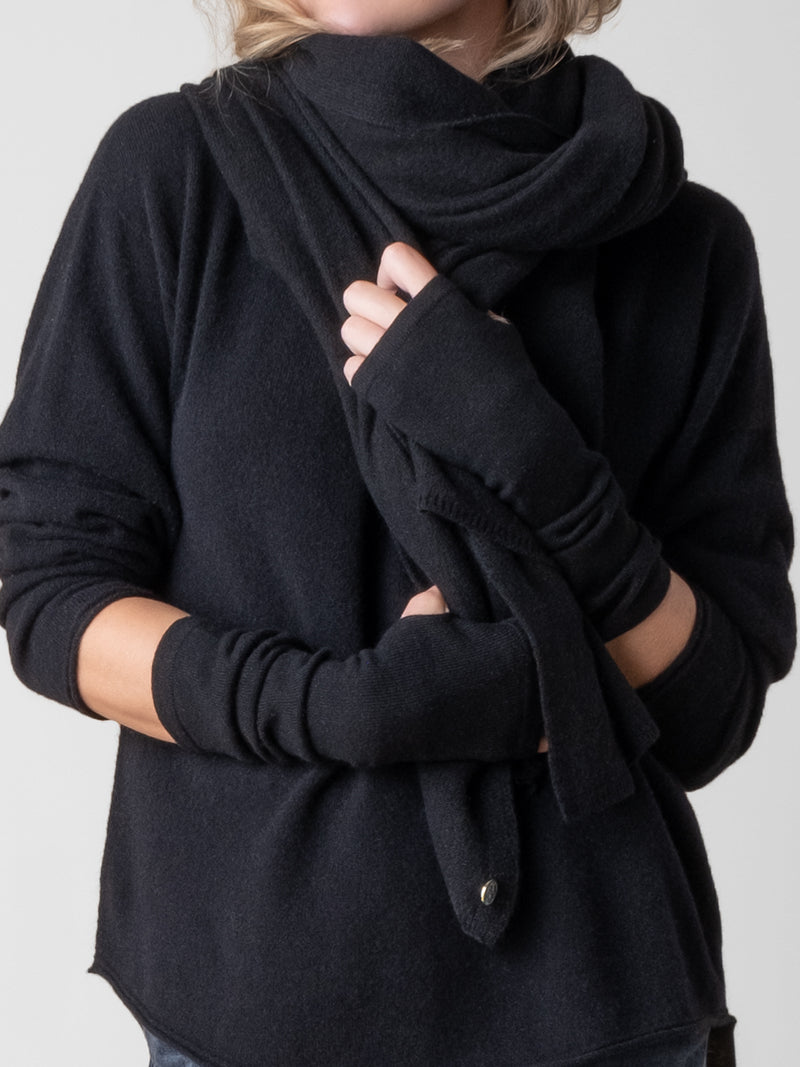 Model wearing a black pullover and a pair of black texting gloves and a black wrap around her neck.