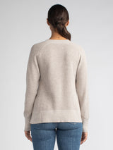 Back view of the model wearing a soy vneck pullover and a pair of jeans.